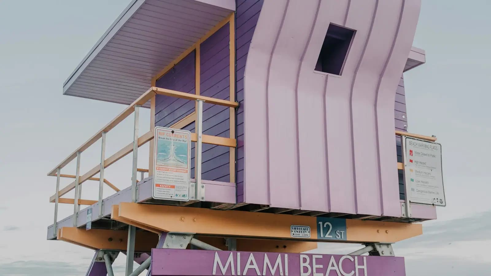 A lilac wooden lifeguard stand on Miami Beach marked with the street number 12