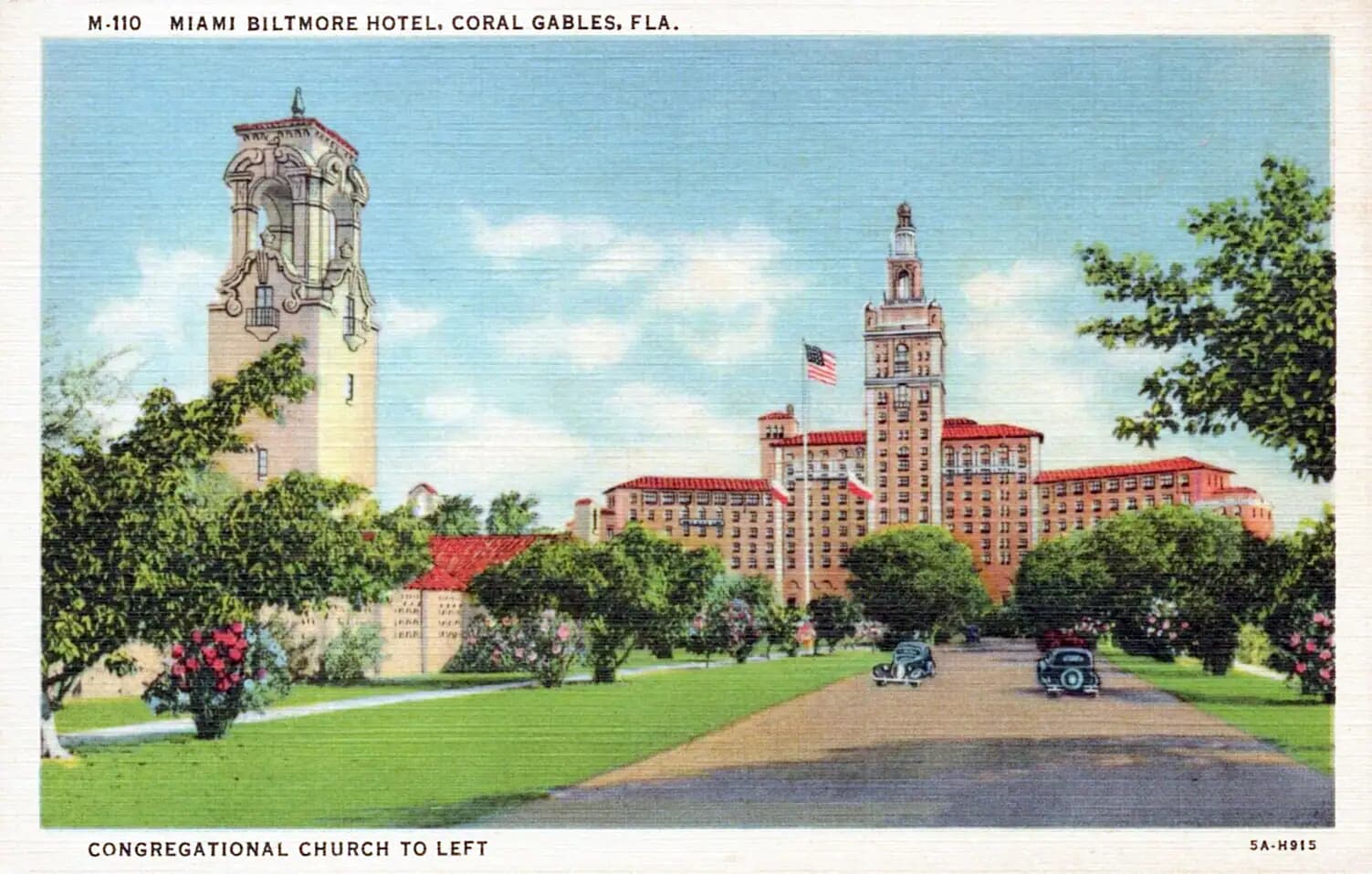 A Mediterranean Revival building with barrel-tile roof, arcades and stucco walls under palms
