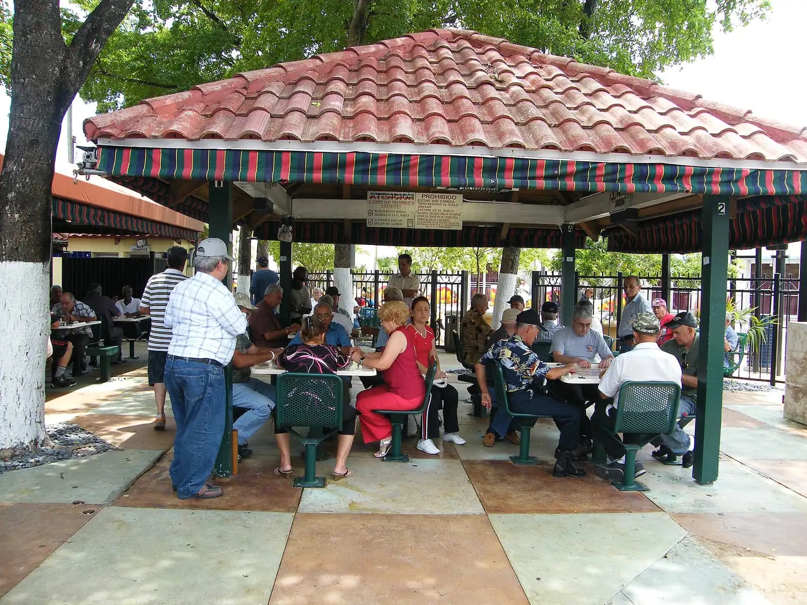 Domino tiles laid out on a tiled table during a game in an outdoor park